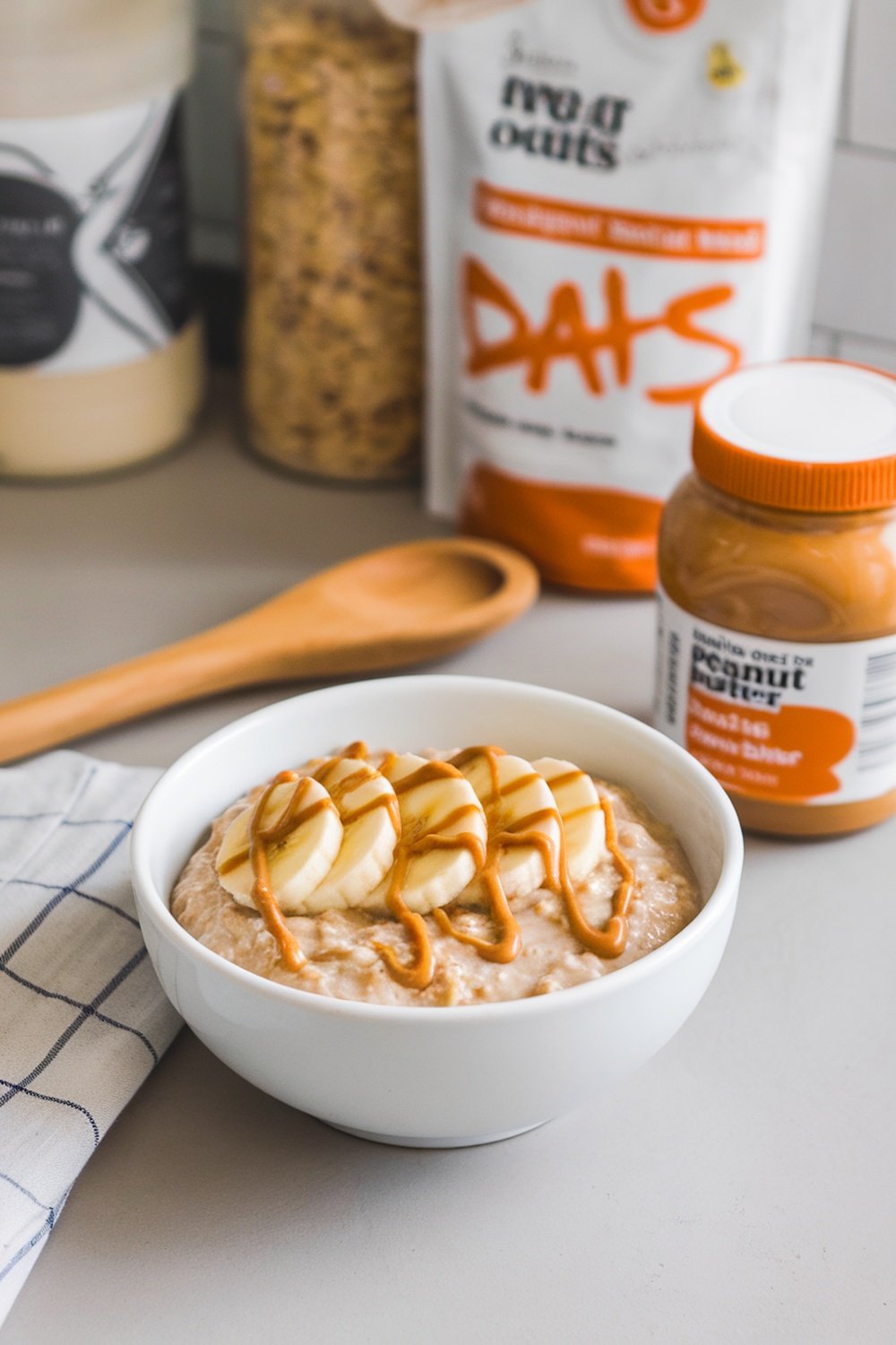 A bowl of peanut butter banana overnight oats topped with banana slices and peanut butter drizzle.